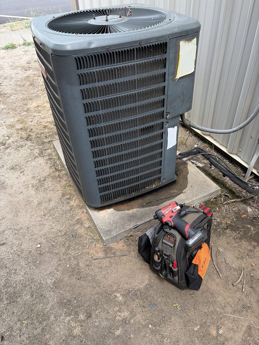 Outdoor HVAC condenser with technician tool bag